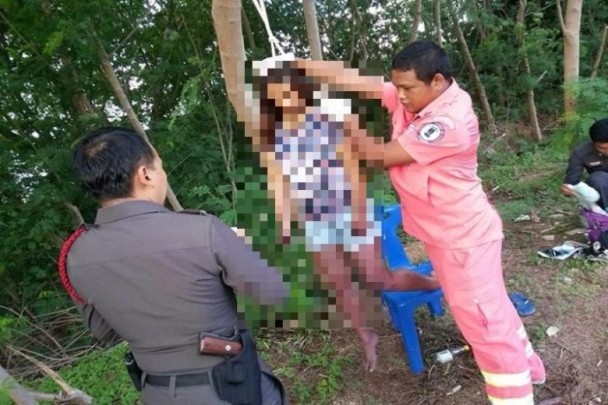 女性の首吊り自殺死体を下ろす警察官