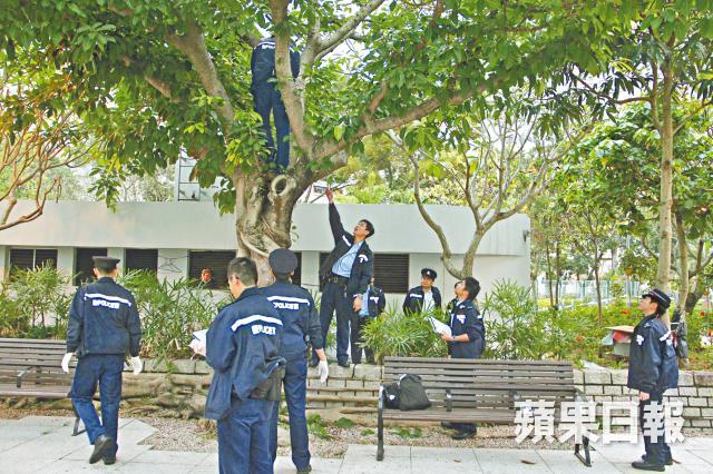 首吊り自殺死体を見上げる警察官