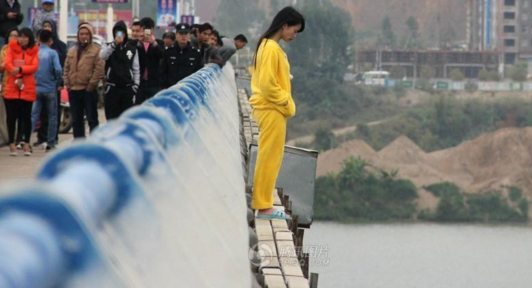 橋から飛び降り自殺しようとしている黄色い服の女